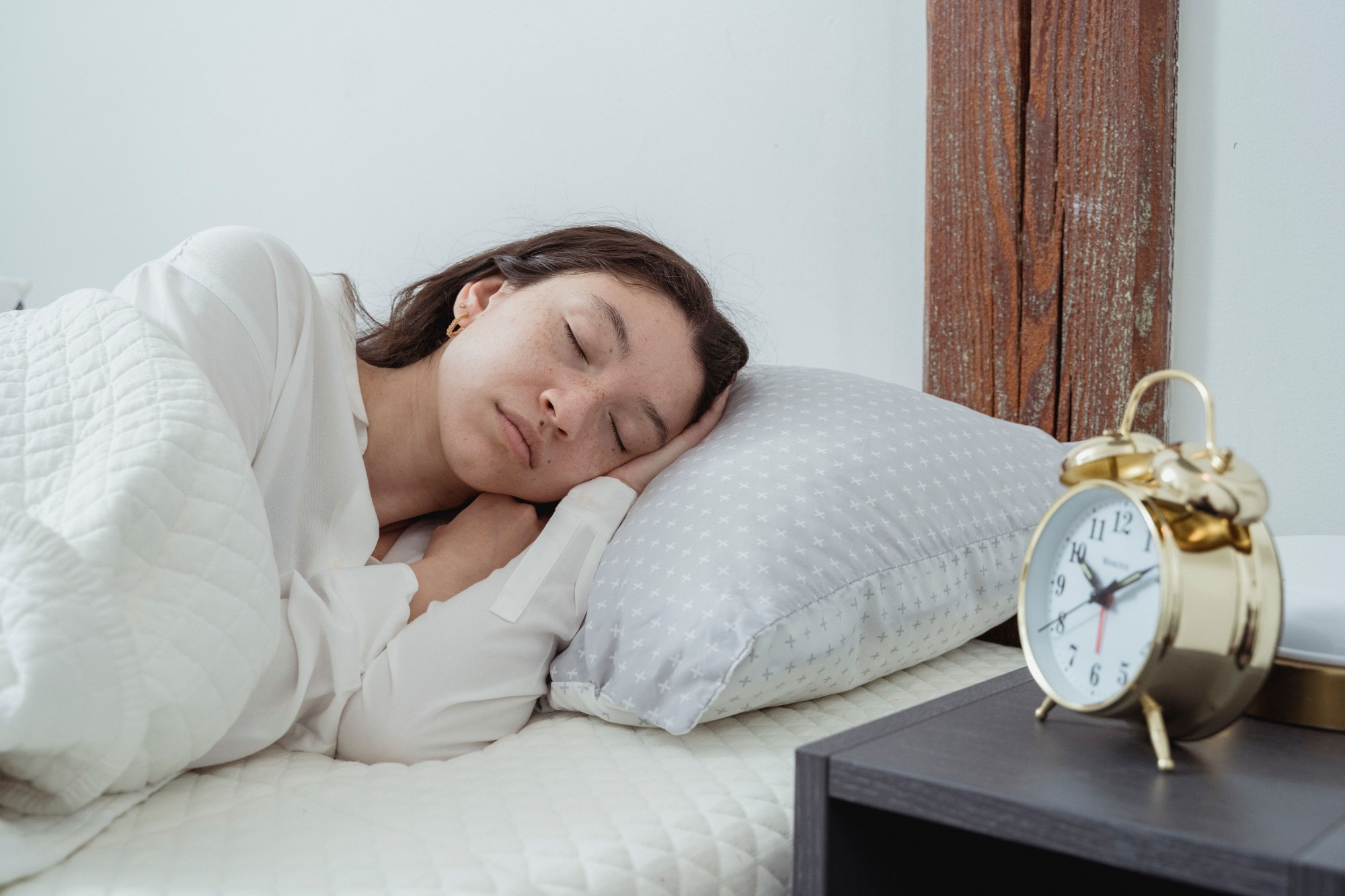 Woman sleeping peacefully beside an alarm clock
